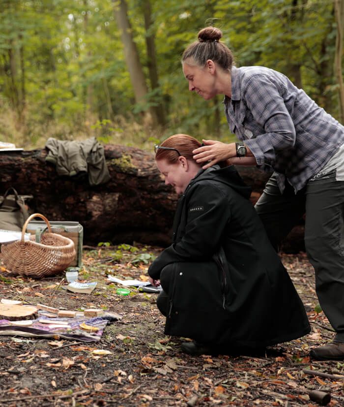 Two people in forest taking engaging in a team building activity